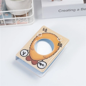 Close-up of beige 3-inch mini photo album with cartoon fried shrimp and round window