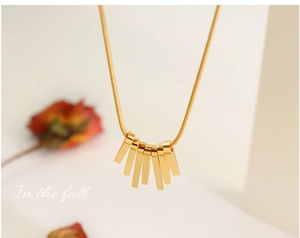 Detailed shot of golden snake chain with fan-shaped rectangular bar pendant set