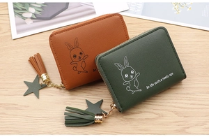 Detail of candy-colored wallets with star charms, tassel zippers and bunny prints