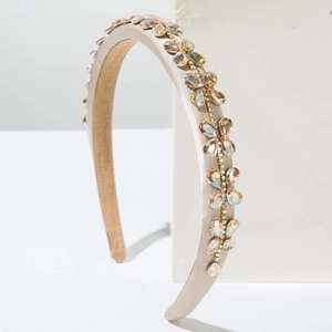 Detail of baroque headband with champagne silk and sparkling rhinestones on white blocks
