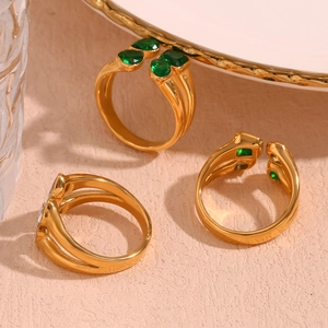 Detailed macro view of 18K gold-plated double-layer heart rings with green zircon gems