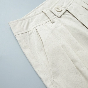 Detailansicht beige Leinenhose mit Knopfverschluss, Falten und natürlicher Stoffstruktur