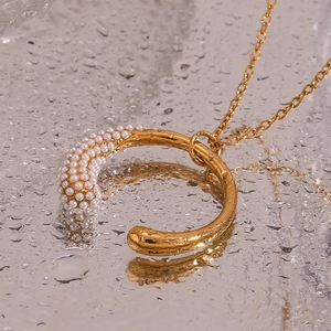 Detailansicht der 18K vergoldeten Perlenkette mit Smiley-Anhänger auf einer Spiegeloberfläche
