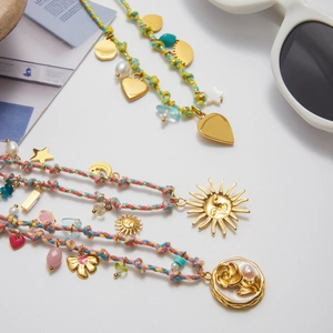 Bohemian style woven necklaces with gold heart, sun, and rose flower charms detail