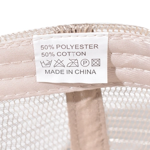 Macro detail of washing label showing 50% cotton and 50% polyester composition on mesh cap