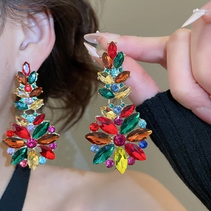 Detailed macro view of vibrant colorful gemstone floral drop earrings in gold setting