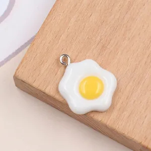 Macro detail of a resin fried egg charm with a silver metal jump ring for DIY crafts