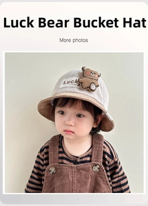 Detailed close-up of baby fisherman hat featuring cute bear patch and striped texture