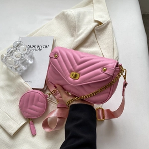 Detail of pink quilted shoulder bag with chain, turn-lock closure and round coin purse