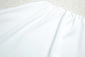 Detail der weißen, hochdichten elastischen Stofftextur mit weichen natürlichen Falten