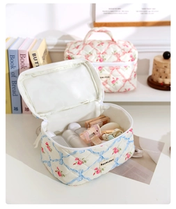 Floral quilted cosmetic bag with pink roses and blue bows in a home lifestyle setting