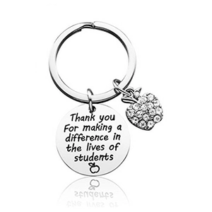 Macro detail of silver teacher keychain with engraved quote and rhinestone apple charm