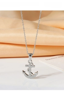 Macro shot of silver pirate ship anchor necklace with sparkling cubic zirconia crystals