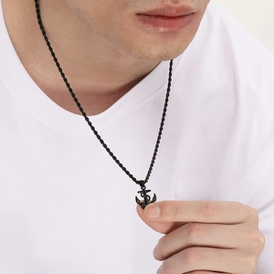 Close-up of a model wearing a black nautical anchor pendant on a twisted rope chain necklace
