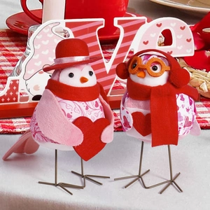 Close-up of Valentine birds figurines on red plaid cloth with love heart background