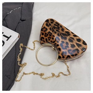 Detail of leopard print clutch with gold metal ring handle and chain strap on blazer