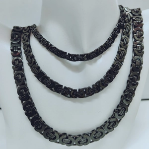 Close-up of triple-layered black Byzantine king chain necklace on a white mannequin
