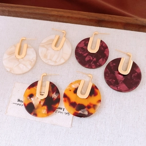 Close-up of 18K gold-plated acetate earrings in marble and tortoiseshell patterns