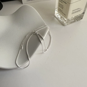 Collana con catena a serpente minimalista in argento sterling S925 su un piatto di ceramica
