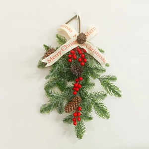 Detail of Christmas wreath with pine branches, red berries, and Merry Christmas ribbon