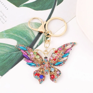 Macro di cristalli colorati e strass incastonati su un portachiavi a farfalla dorato