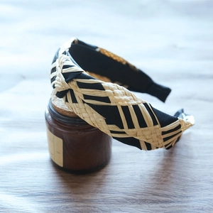 Detail shot of black fabric headband featuring beige raffia geometric weave patterns