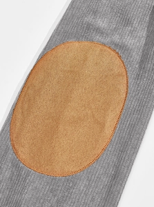 Close-up of grey corduroy polo fabric with a brown oval faux suede patch and fine stitching
