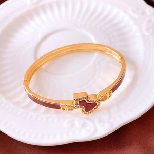 Detail of 18k gold plated bracelet with red enamel heart and zircon inlay craft