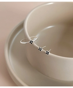 Minimalist S925 silver black clover stud earrings and ring set on beige ceramic