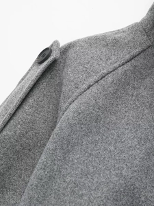 Detail view of the gray woolen coat showing shoulder strap and premium fabric texture