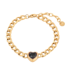 Detailed macro view of gold-plated Cuban chain with heart-shaped gemstone and S.STEEL stamp