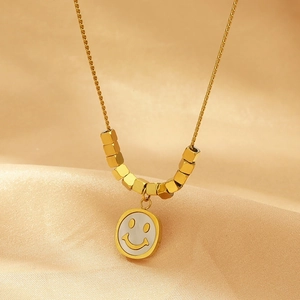 Macro view of gold smile pendant with white inlay and geometric hexagonal beads