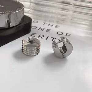 Polished silver geometric hoop earrings with parallel grooves and minimalist industrial style