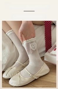 Close-up of white mesh socks with Sweet heart lace patch and elastic ruffled cuffs