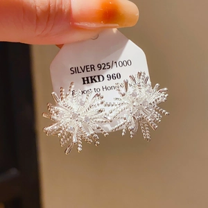 Détail de boucles d'oreilles en argent 925 en forme de feu d'artifice avec pavé