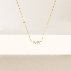 Detail of gold S925 silver necklace featuring delicate four-petal flower charms with zircons