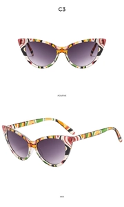 Detail of cat-eye sunglasses with colorful abstract pattern frames and purple gradient lenses