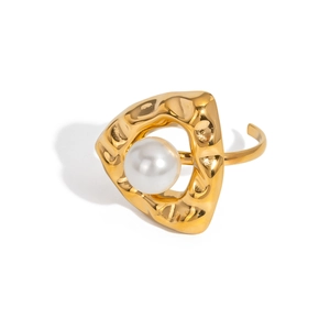 Vue détaillée d'une bague ouverte en métal doré martelé avec une perle blanche