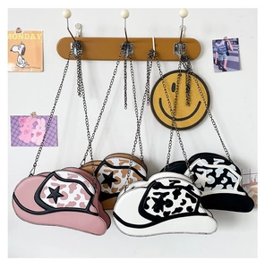 Cowboy hat shaped crossbody bag with star detail and animal print trim on display