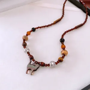 Vintage boho beaded necklace with iridescent cat pendant and amber-toned glass stones