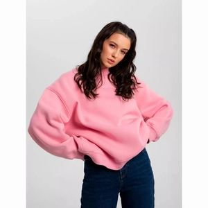 Detail of pink crewneck sweatshirt featuring subtle neck lettering and premium fabric