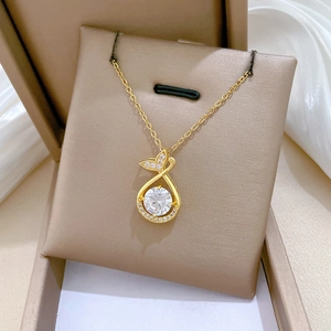 Macro shot of gold fishtail pendant with sparkling round zircon and micro-pave detailing
