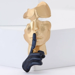 Broche créative en émail avec visage abstrait doré et geste de la main noire en alliage