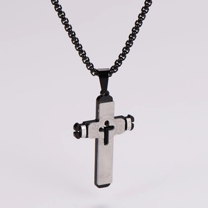 Detail of double-layer stainless steel cross pendant with Greek key pattern on white background