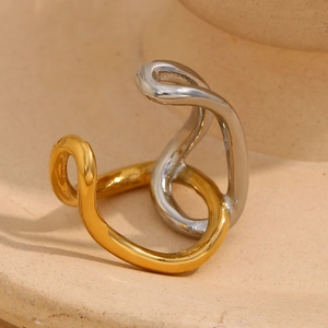 Macro shot of two-tone gold and silver wavy ring on minimalist ceramic surface