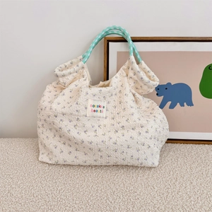 Detail of the bubble fabric texture and purple floral pattern on the tote bag