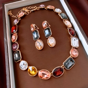 Close-up of vintage gold jewelry set with multi-colored crystals in a brown gift box