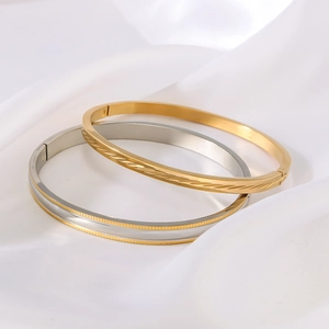Bracciali in acciaio inossidabile dorato e bicolore su sfondo di seta bianca