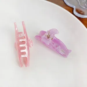 Glittery candy-colored dolphin hair claws in pink and purple marbled acrylic
