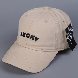 Λεπτομερής άποψη του μαύρου κεντήματος 'LUCKY' σε μπεζ βαμβακερό καπέλο του μπέιζμπολ